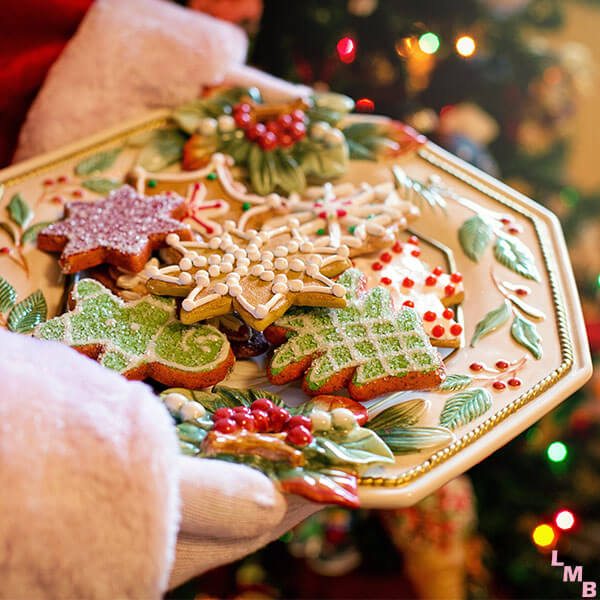 Santa Claus holding plate of decorated cookies